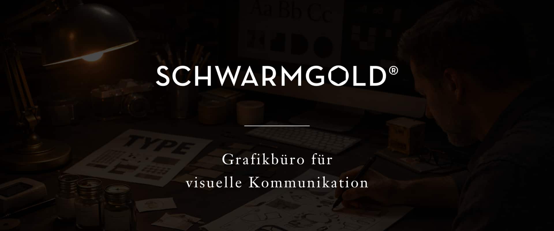 Breites Studio-Hero: Designer rechts zeichnet, links Schreibtischlampe; Typo-Bogen, Stifte, Monitor – Schwarmgold®.